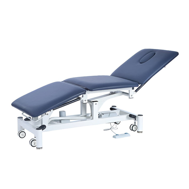 A three-section bariatric treatment table with navy blue upholstery, featuring electric Hi-Lo operation and adjustable sections for patient positioning.