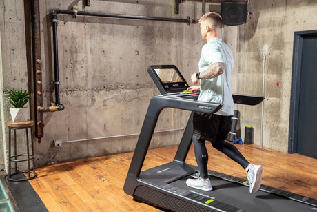 Person using a treadmill in a gym setting.