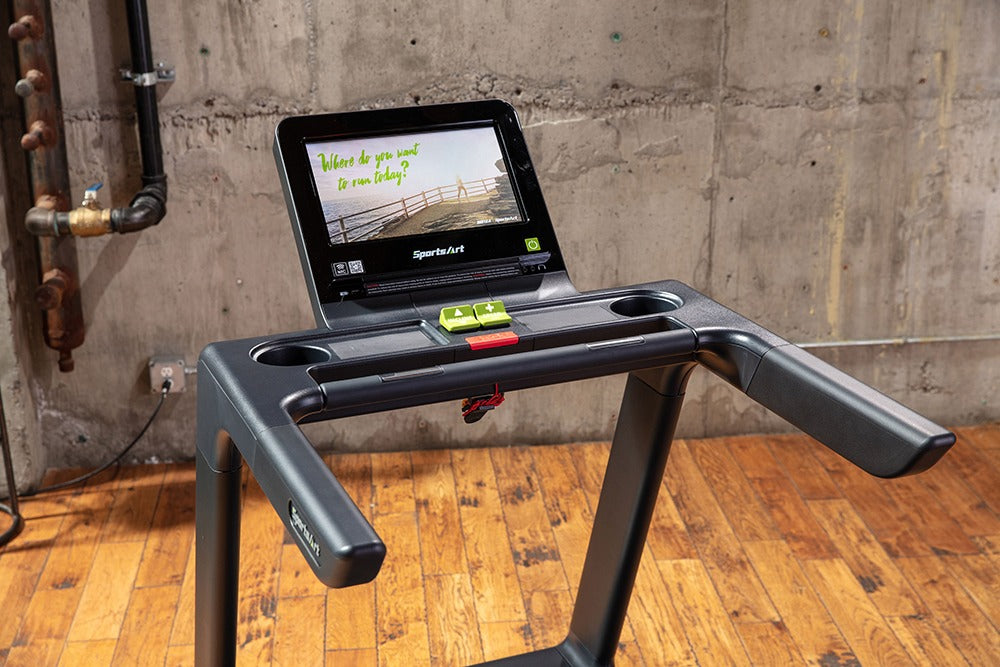 A cropped photo of a black modern treadmill with an operaing system displayed in an indoor setting.
