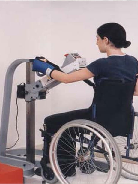 A woman seated in a wheelchair is doing an exercise using an APT device.