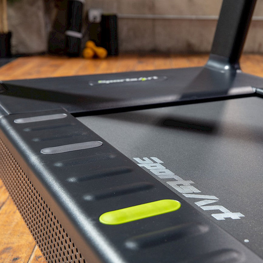 A treadmill set on the gym floor reading for using.
