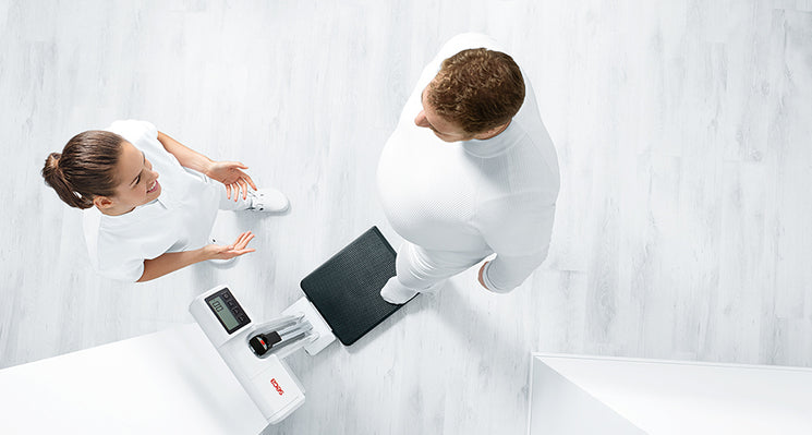 A healthcare professional and a patient in a clinical discussing a patient's chart .